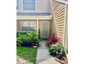 Inviting home entrance with a well-kept walkway, lush landscaping, and secure storm door at 3615 Pine Knot Dr, Valrico, FL 33596