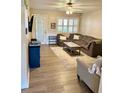 Inviting living room features a plush sectional, ceiling fan, and wood-look flooring at 3615 Pine Knot Dr, Valrico, FL 33596