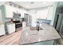 Modern kitchen featuring white cabinets, stainless steel appliances, and granite countertops at 37230 Poinsettia Ave, Dade City, FL 33525