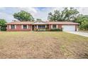 Red brick single-story home with manicured lawn, white trim, and attached garage, offering great curb appeal at 414 Cactus Cir, Seffner, FL 33584