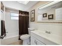 Well-lit bathroom with a shower-tub combo, single sink vanity, and neutral decor at 4408 Rudder Way, New Port Richey, FL 34652