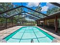 Inviting screened-in pool with brick pavers, outdoor seating, and a view of the backyard at 4706 Scott Rd, Lutz, FL 33558