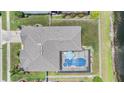 Aerial of backyard with pool, screened enclosure, privacy fence and view of a pond at 5049 Rushbrook Rd, Land O Lakes, FL 34638