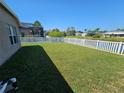 Expansive backyard features lush green grass and a secure white fence, ideal for outdoor activities and privacy at 5049 Rushbrook Rd, Land O Lakes, FL 34638