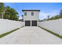 Features a spacious driveway leading to a two-car garage, enclosed by a crisp white fence at 5055 2Nd S Ave, St Petersburg, FL 33707