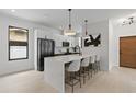 Bright, modern kitchen featuring a quartz island, pendant lighting, black appliances, and sleek white cabinets at 5055 2Nd S Ave, St Petersburg, FL 33707