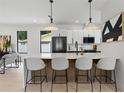 Modern kitchen features a large center island with bar seating, pendant lighting, and stainless steel appliances at 5055 2Nd S Ave, St Petersburg, FL 33707