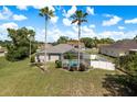 Beautiful backyard with a screened-in pool area, palm trees, and well-maintained landscaping at 6129 Schalekamp Dr, Spring Hill, FL 34609