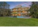 A spacious backyard with a pool, dining table, grill, lush green lawn, and multi-level balconies, ideal for outdoor living at 614 Norton St, Longboat Key, FL 34228