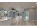 Bright and airy living room with wood floors, modern fans, and sliding doors to the patio at 632 S Florida Ave, Tarpon Springs, FL 34689