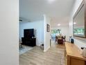 Open-concept living area with light wood floors and view to dining space at 6521 Cedarbrook S Dr, Pinellas Park, FL 33782