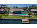 Aerial view of waterfront home with pool, lanai, dock and fenced yard at 671 Tallahassee Ne Dr, St Petersburg, FL 33702