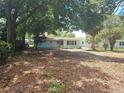 Green backyard with trees, view of the home at 6731 Old Main St, New Port Richey, FL 34653