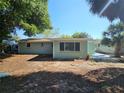 View of the backyard with mature trees and green grass at 6731 Old Main St, New Port Richey, FL 34653