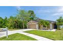 Single-story home with a well-maintained lawn, landscape beds, and a welcoming driveway and walkway at 8504 Tidal Bay Ln, Tampa, FL 33635
