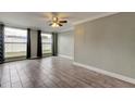 Inviting living room with large windows, modern tile flooring, ceiling fan, and neutral paint, offering a comfortable living area at 9120 Lunar Ln, Port Richey, FL 34668