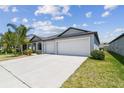 Single-story home featuring a spacious driveway, lawn, and landscaping at 10822 Crushed Grape Dr, Riverview, FL 33578