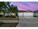 Charming single-story home featuring a spacious driveway and well-maintained landscaping at dusk at 10822 Crushed Grape Dr, Riverview, FL 33578