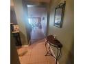 Inviting hallway with tile flooring leading to a spacious living area, complemented by a decorative table and mirror at 10850 Lake Saint Charles Blvd, Riverview, FL 33578