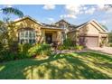 Beautiful home featuring lush landscaping, large windows, and a three-car garage at 1116 Hillandale Reserve Dr, Tampa, FL 33613