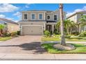 Lovely two-story home displaying a brick driveway, lush landscaping, and a welcoming front facade at 11419 Emerald Shore Dr, Riverview, FL 33579