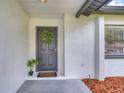 Inviting front door with a wreath and a cute welcome mat on the front porch at 11520 Bear Paw Ln, Port Richey, FL 34668