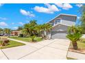 Gray two-story home with well-manicured landscaping, a two-car garage, and a paved driveway at 1213 Barmere Ln, Brandon, FL 33511