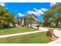 Charming two-story home featuring a well-manicured lawn and tropical landscaping, enhancing its curb appeal at 1213 Barmere Ln, Brandon, FL 33511