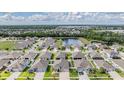 Aerial view of a residential community featuring a pond, lush greenery, and single Gathering homes at 12420 Brick Cobblestone Dr, Riverview, FL 33579