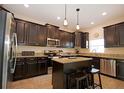 Modern kitchen featuring stainless steel appliances, granite countertops, and a functional island with breakfast bar at 13752 Tensaw Dr, Hudson, FL 34669