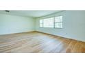 Spacious bedroom featuring wood-look flooring and a large window for ample natural light at 2132 Sandpiper Dr, Clearwater, FL 33764