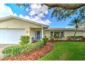 Inviting front entrance with a blue door, manicured bushes, and mulch landscaping at 2132 Sandpiper Dr, Clearwater, FL 33764