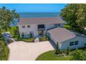 Beautiful two-story white home with manicured landscaping, a circular driveway, and stunning water views at 218 Colony Point S Rd, St Petersburg, FL 33705