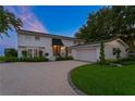 Charming white two-story home with a well-maintained lawn, circular driveway, and attached garage at 218 Colony Point S Rd, St Petersburg, FL 33705