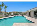 Beautiful outdoor pool featuring deck chairs, a boat dock and tropical landscaping with sunny skies at 2773 Seabreeze S Dr, Gulfport, FL 33707