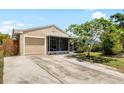 Charming single-story home featuring a screened porch, attached garage and a paved driveway at 2807 Northcote Dr, Palm Harbor, FL 34684