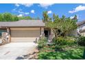 Charming home featuring an attached garage, well-maintained landscaping, and mature trees at 3923 Shoreside Cir, Tampa, FL 33624