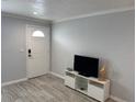 Cozy living room featuring modern flooring and a stylish entertainment center against a soothing neutral wall at 4103 Gulf Blvd # 104, St Pete Beach, FL 33706