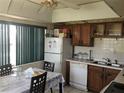 Functional kitchen with white appliances, wood cabinets, and a bright dining area near a window at 4819 21St S Ave, St Petersburg, FL 33711