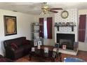 Cozy living room with a brick fireplace and mantel, complemented by a ceiling fan and warm lighting at 4819 21St S Ave, St Petersburg, FL 33711