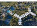 Aerial view of resort-style living with multiple tennis courts, a community pool, and convenient parking at 618 Bird Bay S Dr # 111, Venice, FL 34285