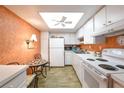 Bright kitchen featuring white appliances and cabinets, complemented by wood-look flooring and a breakfast nook at 618 Bird Bay S Dr # 111, Venice, FL 34285