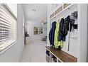 Bright foyer with tile flooring, a convenient coat rack and bench, and views into the living area at 6542 95Th N Pl, Pinellas Park, FL 33782