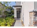 Inviting front entrance with a covered porch, a stylish gray door, and attractive stone detailing at 6542 95Th N Pl, Pinellas Park, FL 33782