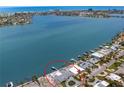 Breathtaking aerial view of a waterfront home with a private dock and in-ground pool at 7060 S Shore S Dr, South Pasadena, FL 33707