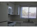 Cozy kitchen featuring sleek, white cabinets, countertops, and stainless appliances at 7927 Kosi Palm Pl # 201, Tampa, FL 33615