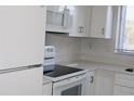 Kitchen has white cabinets and appliances at 7927 Kosi Palm Pl # 201, Tampa, FL 33615