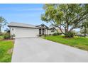 Suburban home featuring well-maintained landscaping, a long driveway, and a two car garage at 8135 Golf Club Ct, Hudson, FL 34667