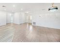 Bright living room featuring neutral tile floors, recessed lighting, and a decorative chandelier at 8744 Andros Ln, Port Richey, FL 34668