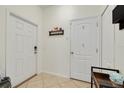 Bright entryway with neutral tile floors, white walls, white doors, and a convenient coat rack at 9520 Trumpet Vine Loop, Trinity, FL 34655